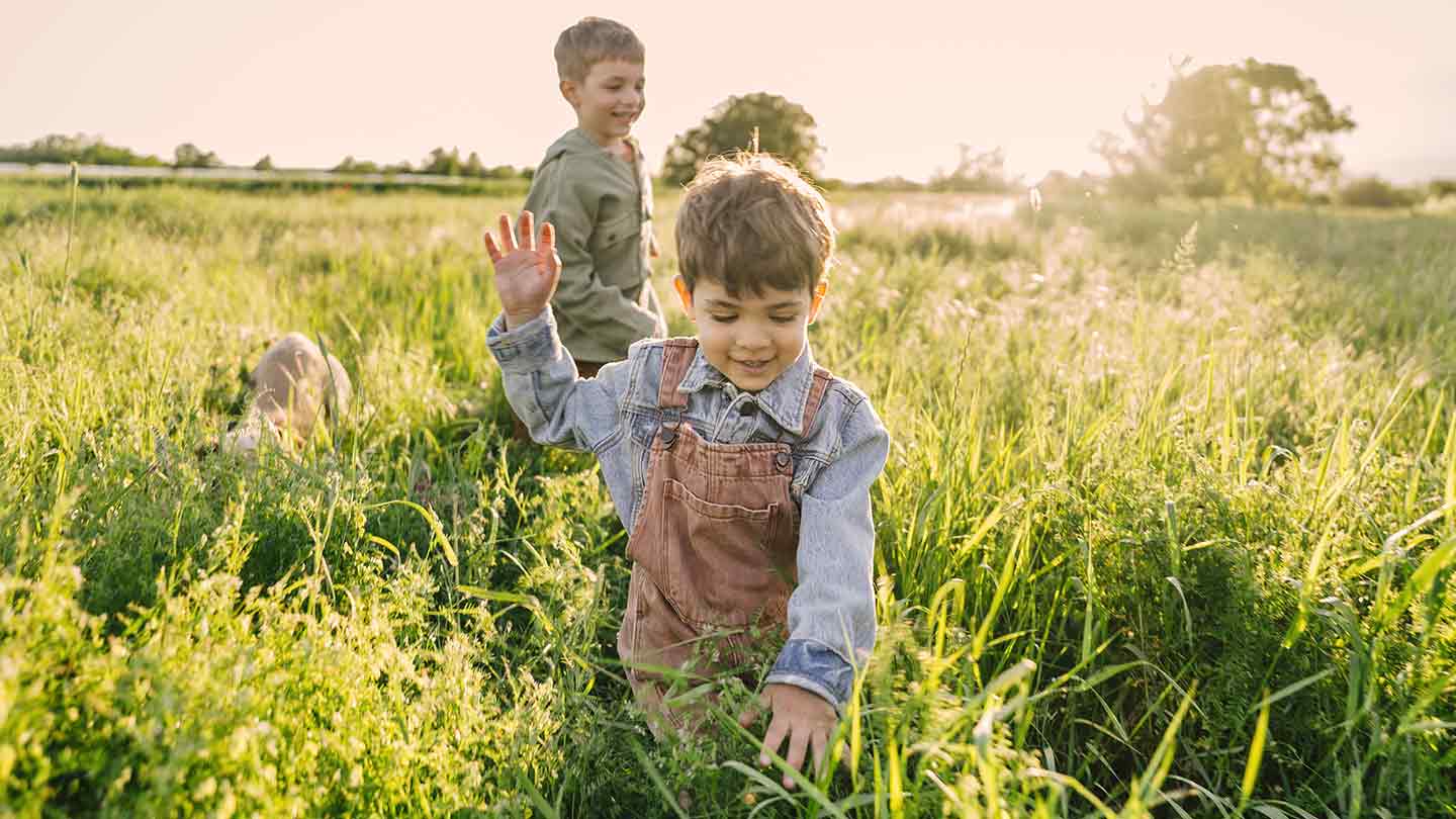 Zwei Jungen, die an einem sonnigen Tag über die Wiese rennen