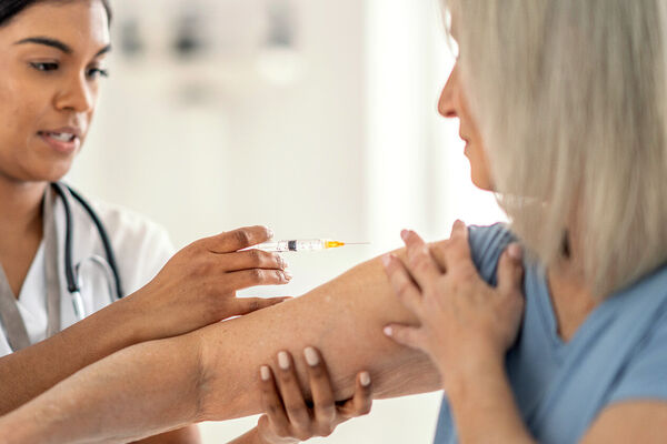 Eine Frau bekommt eine Spritze in den Oberarm.