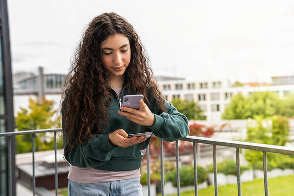 Ein Mädchen macht ein Foto mit ihrem Handy von ihrer elektronischen Gesundheitskarte der SBK.