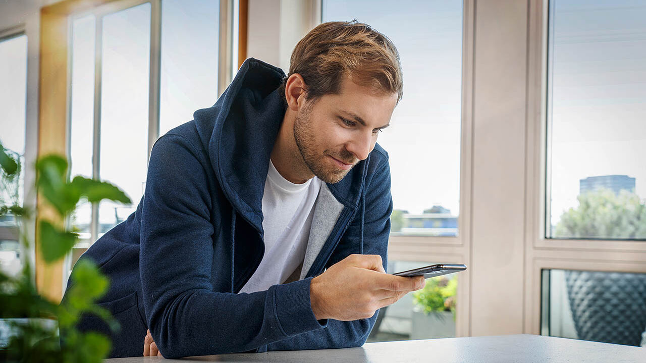 Ein Mann macht mit seinem Handy ein Foto eines Dokuments.