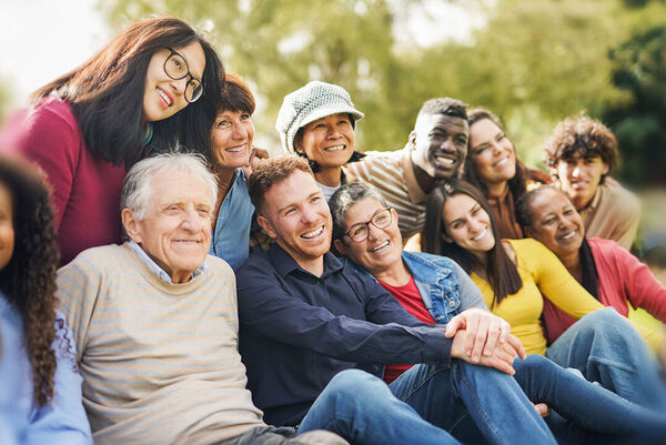 Diverse Menschen sitzen zusammen und sind fröhlich