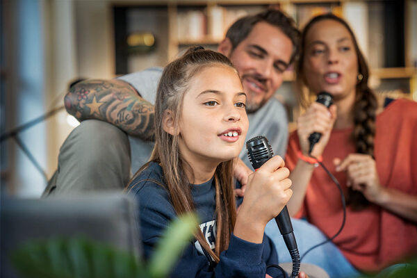 Eine Familie macht einen Karaoke-Spieleabend im Wohnzimmer.