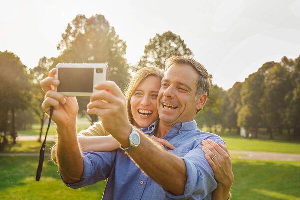 Ein Mann und eine Frau machen gemeinsam ein Selfie im Park.