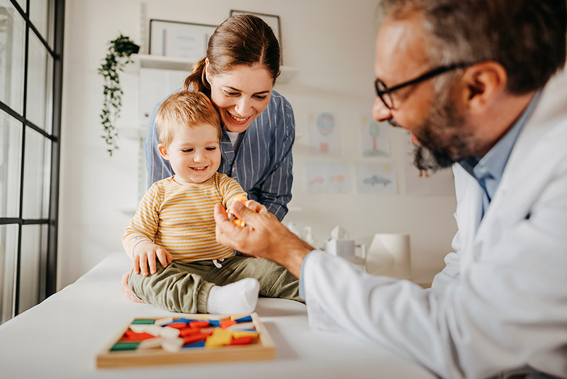 Eine Frau ist mit ihrem Kleinkind bei einer U-Untersuchung.