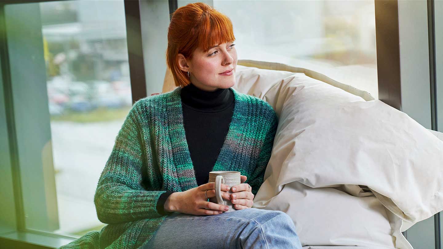 Frau entspannt am Fenster.