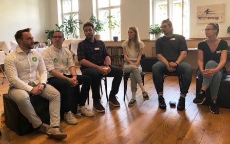 Personen sitzen im Stuhlkreis und diskutieren