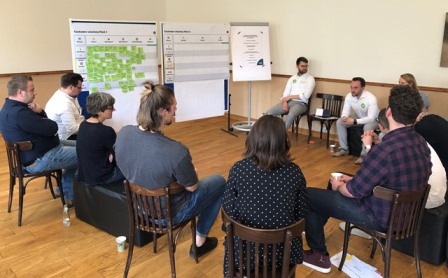 Personen sitzen im Stuhlkreis und diskutieren